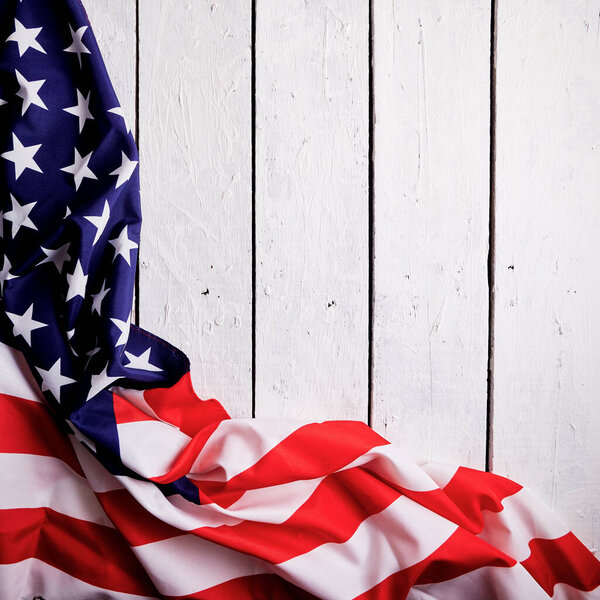 American Flag for the America's 4th of July Celebration over a white wooden rustic background to mark America's Independence Day. Image shot from top view.