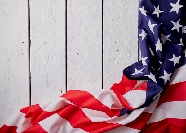 American Flag for the America's 4th of July Celebration over a white wooden rustic background to mark America's Independence Day. Image shot from top view.