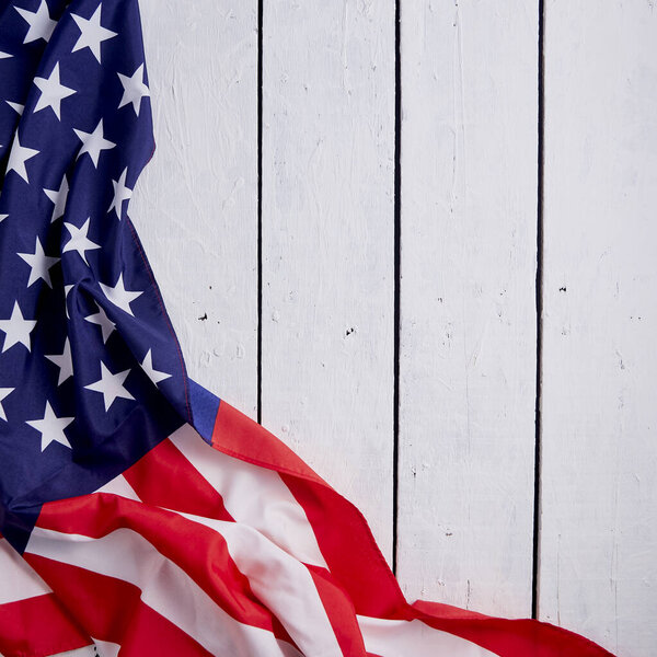 American Flag for the America's 4th of July Celebration over a white wooden rustic background to mark America's Independence Day. Image shot from top view.