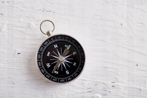 Beyaz tahta masa arka planında pusula, yön, seyahat, rehberlik veya yardım kavramı