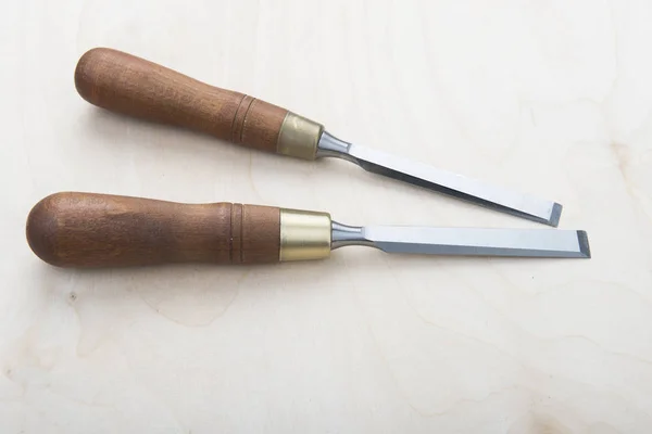 Professional chisels, on a wooden background