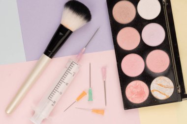 Kozmetik cerrahi vs makyaj, makyaj fırçaları ve şırınga renkli arka planlar üzerinde
