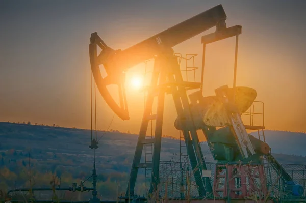 Нефтяной насос на закате — стоковое фото