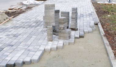 Beton bloklar ve kaldırım taşları profesyonel olarak kumsal temellerine kurulur. Beton bloklar dizilmeye hazır