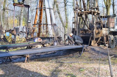 İşçi teçhizatı daha önce delinmiş bir kuyuda çalışıyor. Tamir yoluyla üretimi geri getirmeye çalışıyor.. 