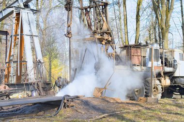 İşçi teçhizatı daha önce delinmiş bir kuyuda çalışıyor. Tamir yoluyla üretimi geri getirmeye çalışıyor.. 