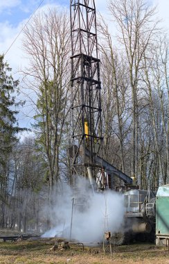 Workover rig working on a previously drilled well trying to restore production through repair.  clipart
