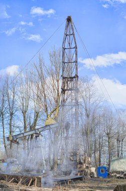 İşçi teçhizatı daha önce delinmiş bir kuyuda çalışıyor. Tamir yoluyla üretimi geri getirmeye çalışıyor.. 