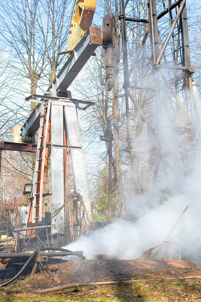 İşçi teçhizatı daha önce delinmiş bir kuyuda çalışıyor. Tamir yoluyla üretimi geri getirmeye çalışıyor.. 