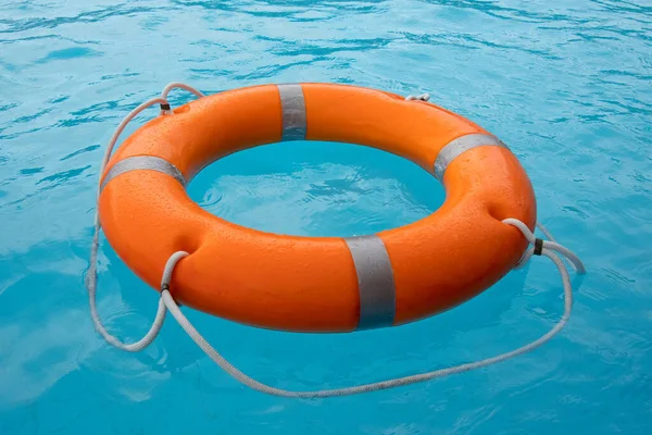 Orange lifebuoy in sea on water. Life ring floating on top of water. Life ring in ocean.