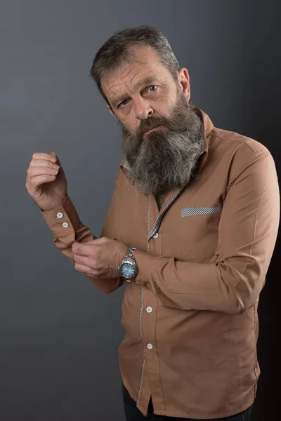 Photo of an angry grumpy old man looking very displeased. Male man with long beard on his face. Close up face looking into the camera.