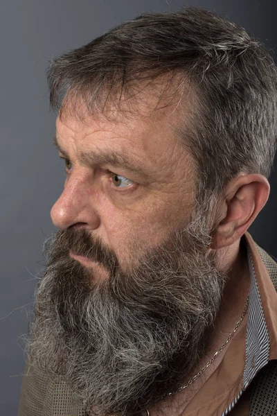 Foto de un viejo gruñón enojado que parece muy disgustado. Hombre con barba larga en la cara. Cara de cerca mirando a la cámara . — Foto de Stock