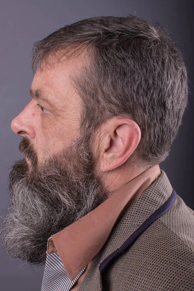 Foto de um velho irritado e rabugento parecendo muito descontente. Homem com barba comprida na cara. Fechar o rosto olhando para a câmera . — Fotografia de Stock