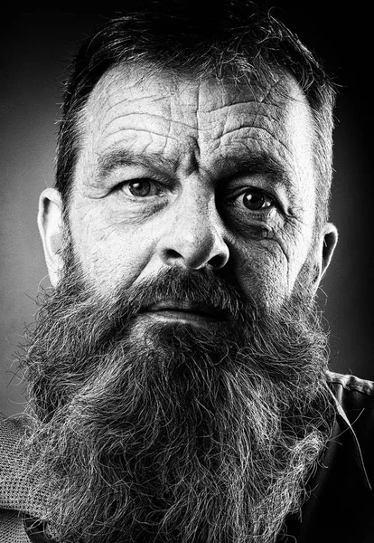 Black and white portrait picture of a senior man with a full beard. Close up head shot with close up of face. Grumpy serious facial expression. — Stock Photo, Image