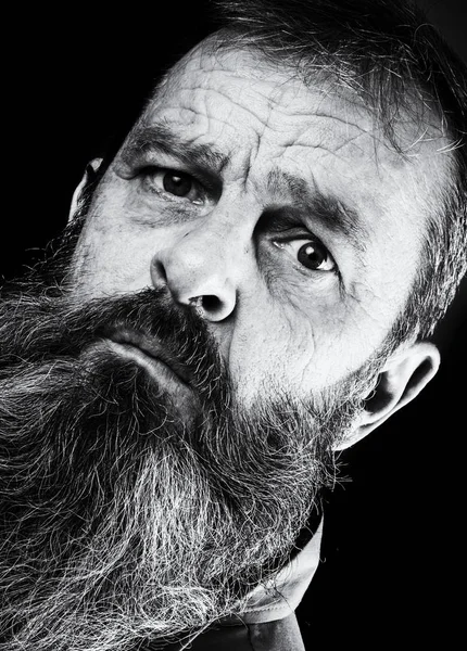 Black and white portrait picture of a senior man with a full beard. Close up head shot with close up of face. Grumpy serious facial expression. — Stock Photo, Image