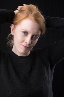 Bir şirin İrlandalı Kızıl saçlı kadın portresi. Kafa ve yüz siyah bir zemin üzerine closeup.