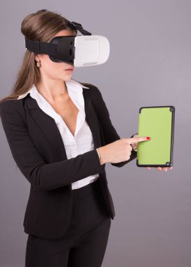 İş kadını giyilebilir teknoloji Vr gözlük. Eller emin genç kadın sanal gerçeklik kulaklık arabirimi seçici odak ile iş takım elbiseli bir tablet boş yeşil ekranda.