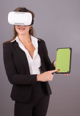 İş kadını giyilebilir teknoloji Vr gözlük. Eller emin genç kadın sanal gerçeklik kulaklık arabirimi seçici odak ile iş takım elbiseli bir tablet boş yeşil ekranda.