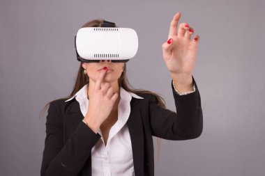 İş kadını giyilebilir teknoloji Vr gözlük. Sanal gerçeklik kulaklık arabirimi seçici odak elleri havada işaret ile iş takım elbiseli kendine güvenen genç kadın 