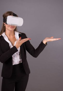 İş kadını giyilebilir teknoloji Vr gözlük. Sanal gerçeklik kulaklık arabirimi seçici odak elleri havada işaret ile iş takım elbiseli kendine güvenen genç kadın 