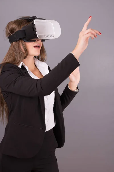 Geschäftsfrau mit tragbarer Technologie und Brille. selbstbewusste junge Frau im Business-Anzug im Virtual-Reality-Headset mit selektivem Fokus und Händen, die in die Luft zeigen — Stockfoto