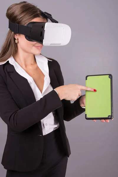 Geschäftsfrau mit tragbarer Technologie und Brille. selbstbewusste junge Frau im Business-Anzug in Virtual-Reality-Headset mit Schnittstelle selektiver Fokus Hände auf einem Tablet leeren grünen Bildschirm. — Stockfoto