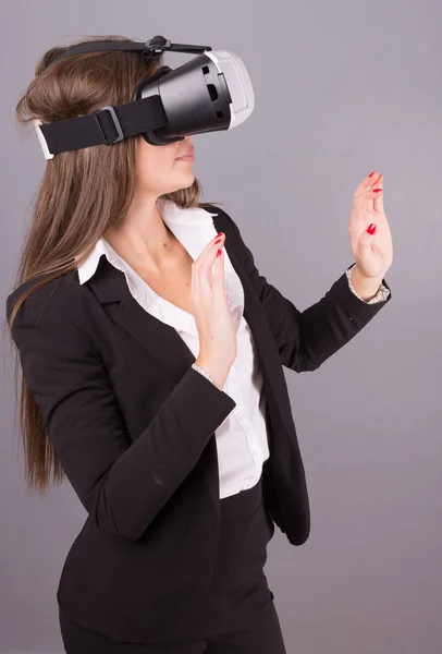 Geschäftsfrau mit tragbarer Technologie und Brille. selbstbewusste junge Frau im Business-Anzug im Virtual-Reality-Headset mit selektivem Fokus und Händen, die in die Luft zeigen — Stockfoto