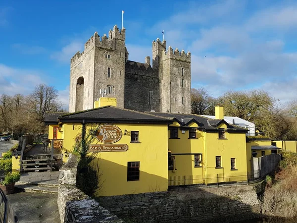 Bunratty Castle y Durty Nelly 's Irish Pub, Irlanda - 30 nov 2017: Hermosa vista del castillo más famoso de Irlanda y el pub irlandés en el condado de Clare. Famosa atracción turística mundial. Bunratty Castle y Durty Nelly 's Pub . — Foto de Stock