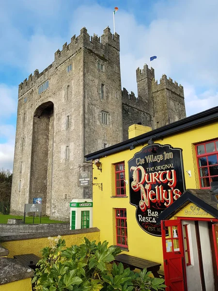 Bunratty Castle y Durty Nelly 's Irish Pub, Irlanda - 30 nov 2017: Hermosa vista del castillo más famoso de Irlanda y el pub irlandés en el condado de Clare. Famosa atracción turística mundial. Bunratty Castle y Durty Nelly 's Pub . — Foto de Stock