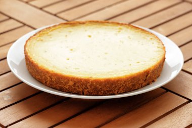 Ahşap masa üzerinde taze pişmiş peynirli kek. Şekerli tatlı