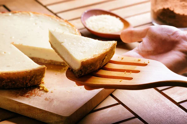 Hand taking piece of freshly baked cheesecake. Sweet dessert — Stock Photo, Image