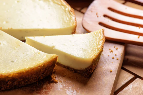 Pedazo de delicioso pastel de queso recién horneado en tablero de madera —  Fotos de Stock