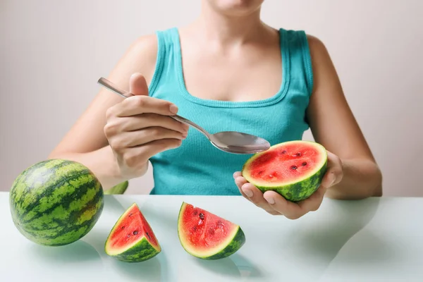 Girl using spoon for eating ripe juicy red small watermelons — Stock Photo, Image