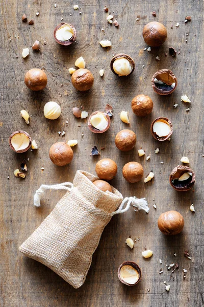 Shelled and unshelled Macadamia nuts on wooden board — Stock Photo, Image