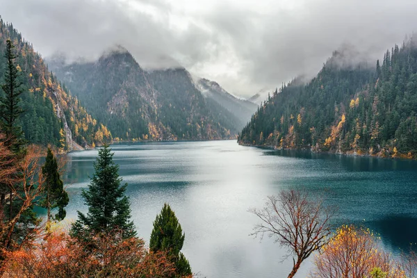 O Lago Longo entre as montanhas arborizadas queda no nevoeiro, Jiuzhaigou — Fotografia de Stock