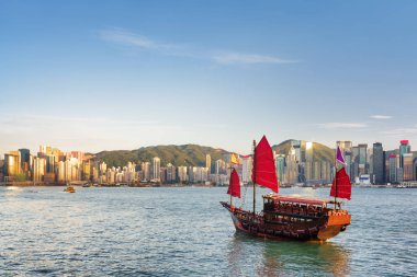 Akşam saatlerinde yelkenli gemi ve Hong Kong Adası manzarası