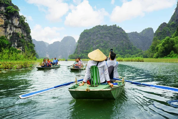 Turistas viajando em pequeno barco ao longo do rio Ngo Dong, Vietnã Fotos De Bancos De Imagens