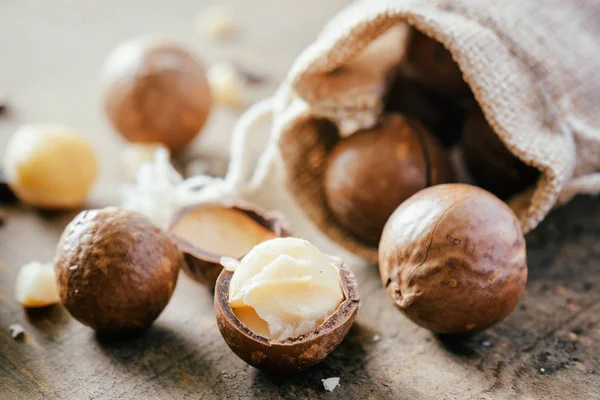 Macadamia nuts on wooden board. Healthy food — Stock Photo, Image