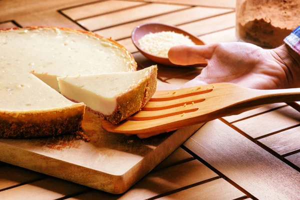 Hand taking piece of freshly baked cheesecake. Homemade dessert — Stock Photo, Image