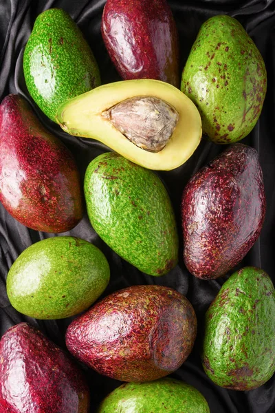 Castas de abacate maduras frescas e coloridas. Frutos verdes e vermelhos — Fotografia de Stock