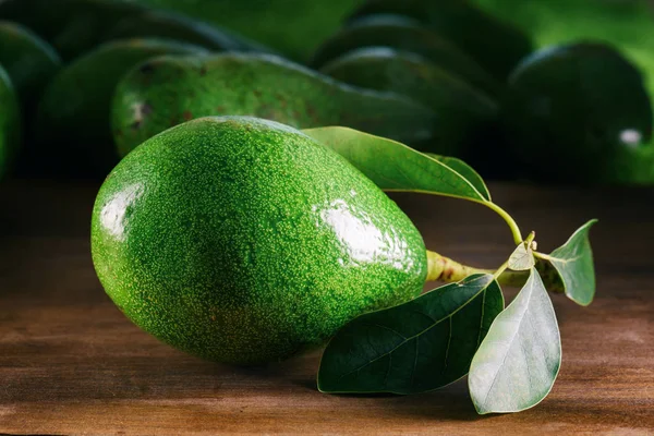 Vedere de aproape a avocado proaspăt coapte cu frunze verzi — Fotografie, imagine de stoc
