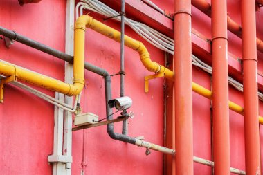 Kırmızı bir bina dışında boru sisteminin görünümü