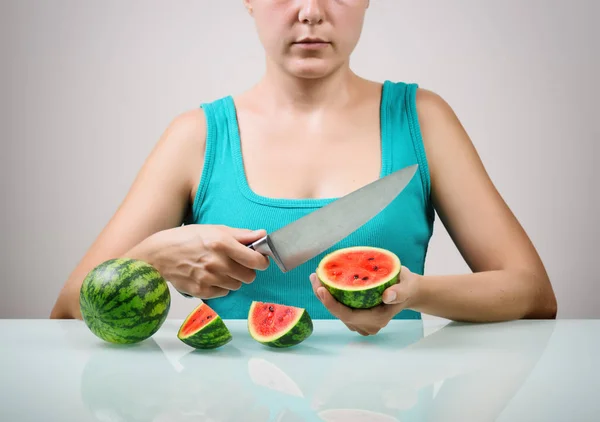 Girl using big knife for cutting juicy red small watermelons — Stock Photo, Image