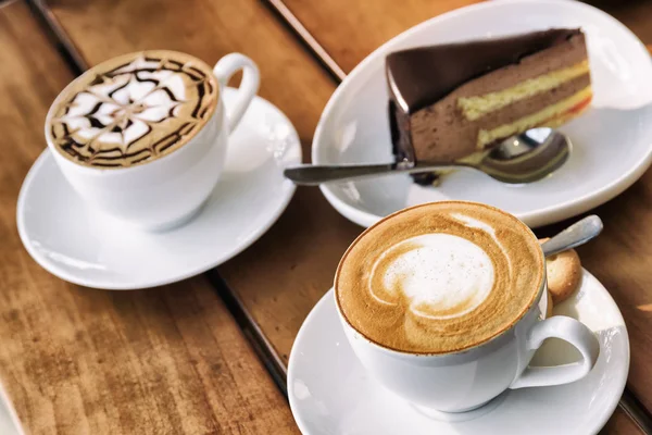 Duas xícaras de café Cappuccino e bolo de mousse de chocolate — Fotografia de Stock