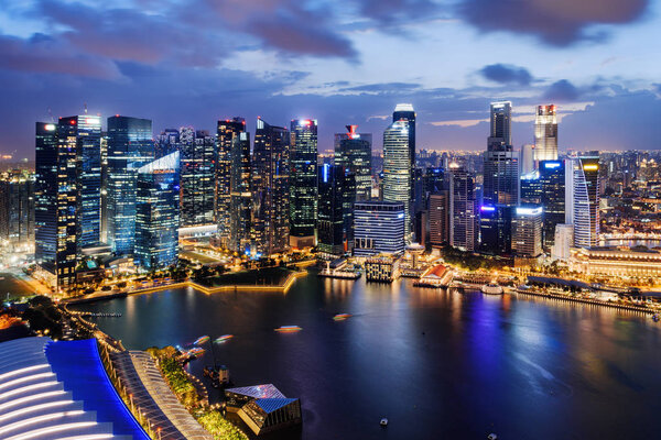 Fantastic night view of skyscrapers at downtown of Singapore. Colorful city lights reflected in water of Marina Bay. Beautiful cityscape. Singapore is a popular tourist destination of Asia.