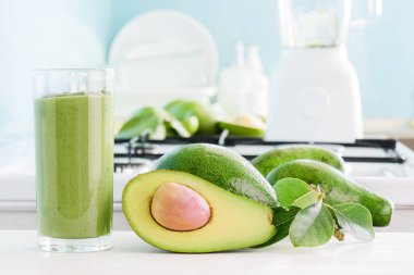 Taze avokado güler yüzlü ve mutfak masasının üzerinde olgunlaşmış avokado