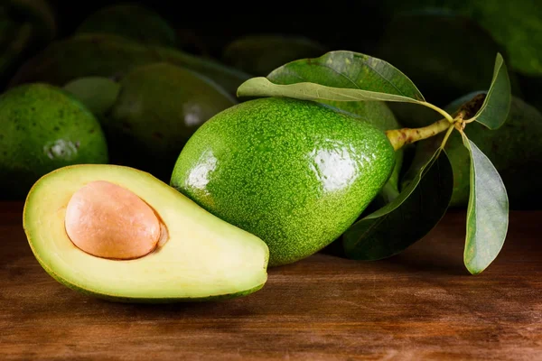 Rijpe avocado op houten tafel. Vers geoogste fruit — Stockfoto