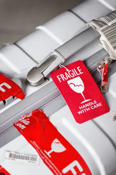 Vue rapprochée de l'étiquette de bagage rouge (fragile) attachée à la valise — Photo