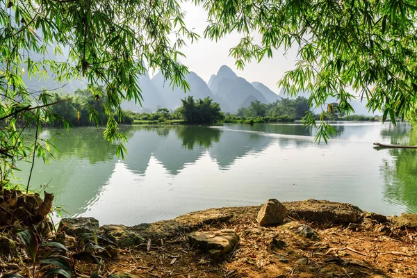 View of the Yulong River and karst mountains through foliage — Stock Photo, Image