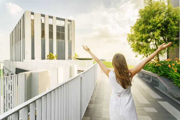Flicka med upphöjda armar till himlen på Rooftop Garden — Stockfoto